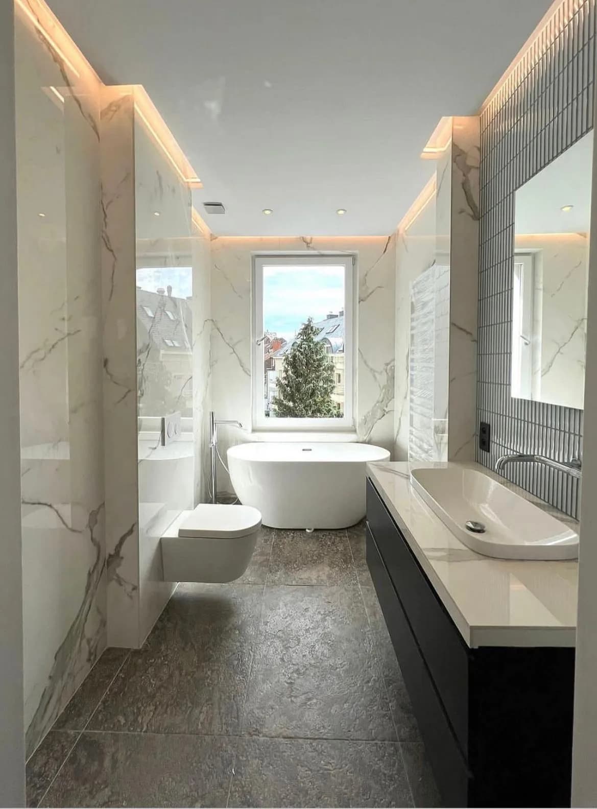 Salle de bain en marbre blanc avec baignoire îlot et meuble suspendu